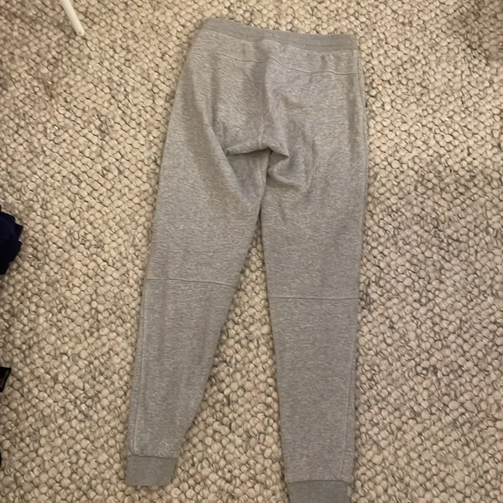 Säljer ett par grå mjukisbyxor från Peak Performance med resår och snörning i midjan samt fickor på sidorna. Byxorna har ribbade muddar vid bensluten och en liten logga tryckt på ena benet. Perfekta för en avslappnad stil.. Farkut & Housut.