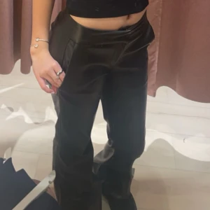 Lågmidjade skinnbyxor - Säljer ett par svarta skinnbyxor med flare oxh låg midja från bershka då de inte kommer till användning 🥰 har sytt upp de lite där nere vid benet eftersom de var för långa på mig som är 160cm, men går att ta bort sömmen och då syns den inte. Normala längden på byxorna passar för de som är ca 165cm och uppåt🥰