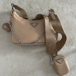 Prada Re-Edition 2005 - Beige Prada Re-edition 2005. Pris idag 17-20k. Kom privat för flera bilder, Äkta med kvitto, original förpackning. 
