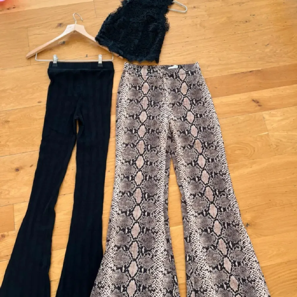 Säljer två par byxor och ett Linne allat från Zara. Ett par med ormskinnsmönster i vida ben och ett par svarta ribbade byxor med utsvängda ben. Ribbade svarta tights, de är inte urtvättade har en ljusare nyans i ribbtyget! Ej slitna i grenen! Leopard byxor härligt fladdrig material, finns lite stretch i dem, bakficka, knäpps med dragkedja och knapp, resår midjan! Sött topp, med dragkedja, spetsen är inte trasig, modellen och spetsen är spretig! Lite nopprig i armhålorna, men lätt att ta bort!. Farkut & Housut.