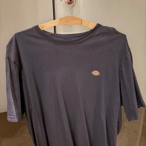 Mörkblå t-shirt från Dickies - Säljer en mörkblå t-shirt från Dickies med liten logga på bröstet. Klassisk passform och rund halsringning, perfekt till vardags. Enkel och stilren design som funkar till det mesta.