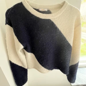 Svart och vit stickad tröja från Gina Tricot - Säljer en stickad tröja från Gina Tricot som är svart och vitt. 