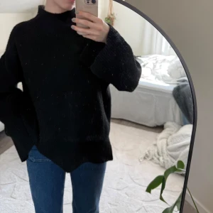 Svart stickad polotröja - Mysig svart stickad polotröja med oversized passform och vida ärmar samt en slits i ärmen. 