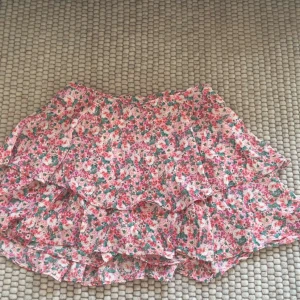 Blommig volangkjol från Zara - söt blommig kortkjol från Zara med volanger. Kjolen är helt ny och med prislappen kvar. Kjolen har shorts under❤️