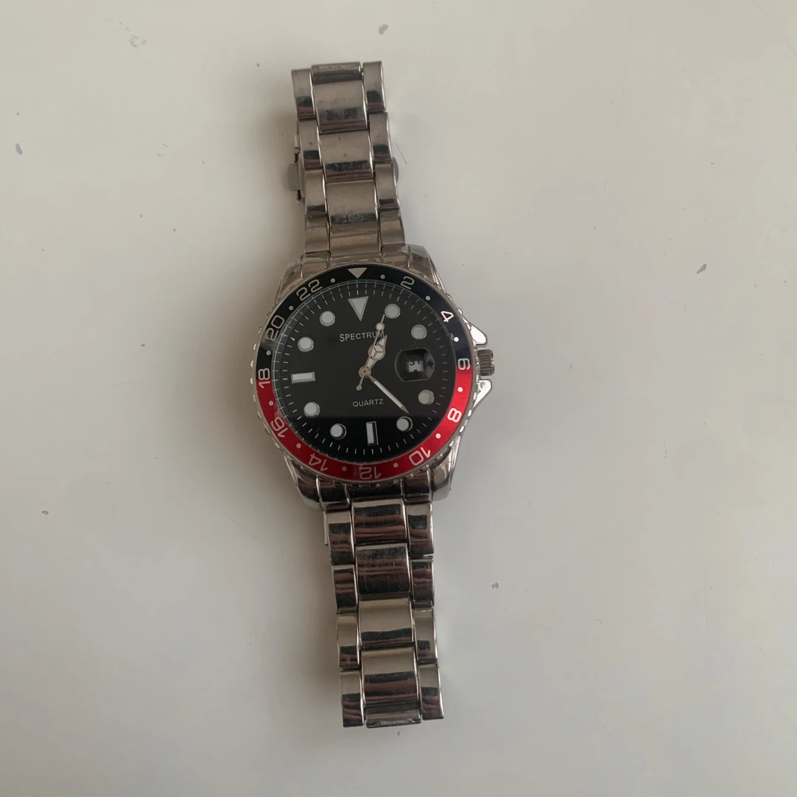 Spectrum silverfärgad klocka med röd/svart ring