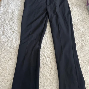 Svarta kostymbyxor med utsvängda ben - Svarta kostymbyxor med hög midja