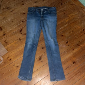 Blå jeans från Gul & Blå, straight fit - Säljer ett par klassiska blå jeans från Gul & Blå med snygga kontrastsömmar och broderade bakfickor. Jeansen har rak passform, normal midja och är tillverkade i slitstarkt bomullsjeans. Perfekta för dig som gillar en tidlös och avslappnad look. Ett litet hål vid dragkedjan se på bild 2 hål genom ena framfickan också