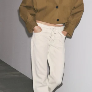 Vita wide jeans med snörning - Säljer ett par vita jeans med lagom breda ben och snygg snörning framtill i midjan. Från zara lch slutsålda i många storlekar. Helr nya och aldrig använda. Kan tyvärr inte postas förens 30 juli