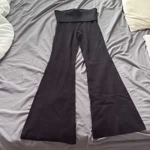 Svarta stickade bootcut-byxor Gina Tricot - Svarta stickade byxor från Gina Tricot i storlek XS. Byxorna har hög midja med bred ribbad mudd och vida ben i bootcut-modell. Mjukt och stretchigt material som sitter skönt och ger en snygg siluett. Pris kan diskuteras vid snabb affär.