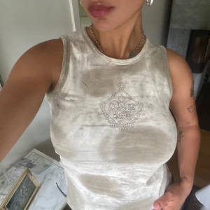 Beige linnetopp med tryck - Säljer en beige linnetopp med tryck! Toppen har en mjuk, lite tvättad look och rund halsringning. Perfekt för dig som gillar en chill och stilren vibe 🥰