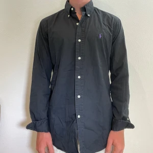 Svart Ralph Lauren skjorta  - Svart Ralph lauren linneskjorta || Storlek S (Custom Fit) || Skjortan är i bra skick, däremot urtvättad || Modellen på bilden är 170cm och väger 62kg || Tveka inte på att höra av dig vid frågor eller funderingar 