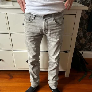 Replay Anbass ljusgrå jeans slim fit - Säljer ett par snygga Replay Anbass jeans i ljusgrå färg. Jeansen har inga defekter, förutom att de kan vara tvättade några gånger så de är såklart inte exakt som köpta men skicket är 9/10. Modellen är 180 cm lång. Hör av er om ni har frågor! Priset kan diskuteras!