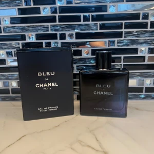 Bleu de Chanel Eau de Parfum 100ml - Bleu de Chanel Eau de Parfum 100ml för herr, med elegant mörkblå glasflaska och svart lock. Kommer i original svart kartong med silvertext. En ikonisk doft från Chanel som utstrålar lyx och stil.