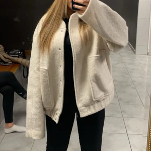 Oversized vit teddyjacka med knappar från PIECES - Säljer en oversized vit teddyjacka med stora fickor och tryckknappar framtill. Jackan har lång ärm, elastisk nederkant och är supermjuk i teddy-material. Perfekt för dig som gillar en chill och trendig look.