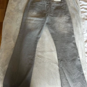 Grå raka jeans från Bohoo - Säljer ett par grå jeans från bohoo med klassisk femficksdesign och raka ben. Jeansen har en neutral grå tvätt och är tillverkade i mjukt jeanstyg. Perfekta för dig som gillar en clean och tidlös look.