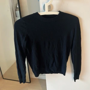 Svart stickad tröja från 157 XS - En svart stickad tröja från 157 i storlek XS. Tröjan har rund halsringning, ribbade muddar och lång ärm. Mjuk och skön känsla, perfekt för kyligare dagar.