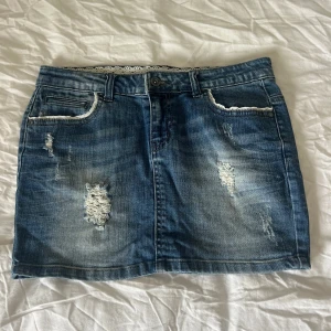 Jeanskjol  - Superfin jeanskjol från only med fina spetsdetaljer vid alla fickor och även inuti. Midjemåttet är 38 cm som på bilden och längden är 31 cm. Storleken är 28 (se bilden) och passar mig som ofta har S eller XS. Skriv vid frågor!