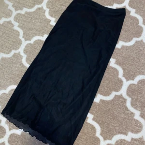 Svart långkjol från SHEIN - Lång kjol från shein. Har aldrig använts men säljer för jag inte gilla den. Den är jätteskön på och går ner till fotlederna på mig som är 158cm lång. Är två lager en som är som silke eller satin och ett över de som är genomskinligt och är lite längre💕