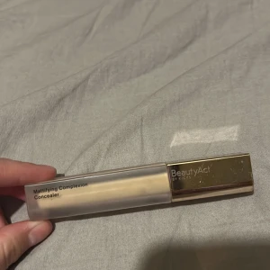 BeautyAct Mattifying Concealer 08W - Mattifying Complexion Concealer i nyansen 08W från BeautyAct. Ger medium täckning med sammetslen känsla och jämnt resultat. Kommer i en stilren fyrkantig tub med guldig kork. Perfekt för att dölja ojämnheter och ge en matt finish. Bara testad på handen