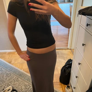 Grå maxikjol - Säljer denna ursnygga maxikjolen ifrån NA-KD! Köptes förra året så i mkt bra skick. Säljer pga att den är lite för lång för mig som är ca 170 cm! Men sitter jättefint, skulle säga att den passar XS-M beroende på hur lång man är! 