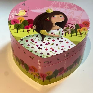 Hjärtformad smyckesask med prinsessmotiv - Supergullig hjärtformad smyckesask i rosa med tecknad prinsessa, körsbär och färgglada träd. Inuti finns en spegel formad som ett hjärta och en snurrande prinsessfigur och som musik. Perfekt för att förvara ringar, armband eller halsband. Helt ny
