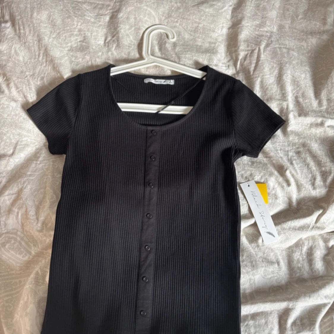 Svart ribbad topp med knappar från Gina Tricot