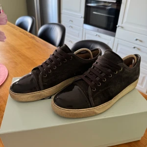 Lanvin grå i använt skick - Utvändigt skulle jag säga att de är i fint skick. Jag kan även garantera äkthet då det finns kvitto från när jag köpte dem hos Care of carl. Kommer med originalkartong och extra skosnören. Det enda anmärkningsvärda är sulans häl som man ser på sista bilden. Annars är det inga konstigheter.     Hör av er vid intresse!