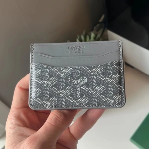 Grå kortfodral  - Säljer ett stilrent grått kortfodral. Fodralet har en gul insida och levereras med originalask. Perfekt för att hålla ordning på dina kort med lyxig känsla.