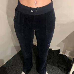 Mörkblå mjukisbyxor med fickor - Mörkblå mjukisbyxor i mjukt material med resår i midjan och snörning framtill. Byxorna har fickor både fram och bak, samt raka ben. Perfekta för en avslappnad stil.