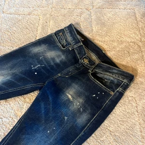 Mörkblå slitna skinny jeans - Säljer ett par mörkblå skinny jeans med slitningar från dondup, Aldrig kommit till använda. 10/10 skick! Hör av dig vid funderingar!