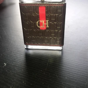 CH Men parfym från Carolina Herrera - Snygg CH Men parfym från Carolina Herrera i en stilren glasflaska med mörkbrunt läderfodral, präglat med CH-loggor och en röd detalj framtill. Silverfärgad kork med CH-gravyr. Maskulin och elegant design som sticker ut i badrumshyllan. Med en väldigt stark och manlig doft. 