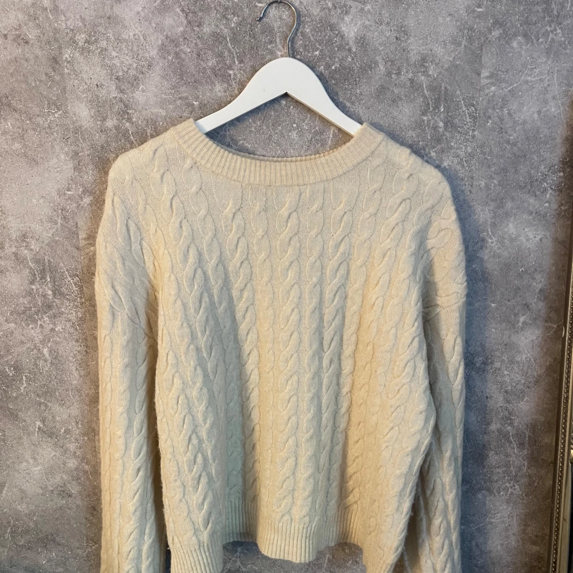 Beige stickad tröja med kabelmönster