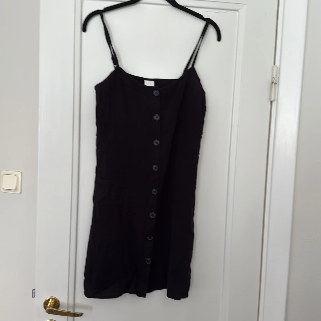 Svart knappklänning med smala axelband