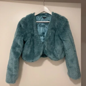 Blå pälsjacka - Snygg blå pälsjacka med mjukt foder och långärmad design. Perfekt för att hålla sig varm och stilren under kyliga dagar. Jackan har en elegant och lyxig känsla.