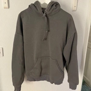 Mörkgrå hoodie - Hej! Säljer en stilren grå hoodie från BikBok i storlek S. Den har en klassisk känguruficka och justerbar huva med dragsko. Perfekt för en avslappnad look. Hör av dig vid frågor/intresse! 