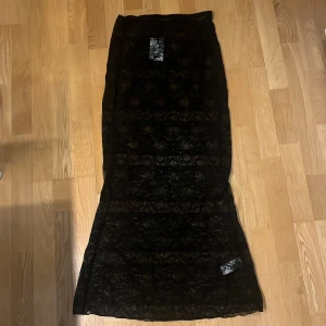 Svart spetskjol från BikBok - Elegant svart långkjol i spets från BikBok. Aldrig använd med prislapp kvar.