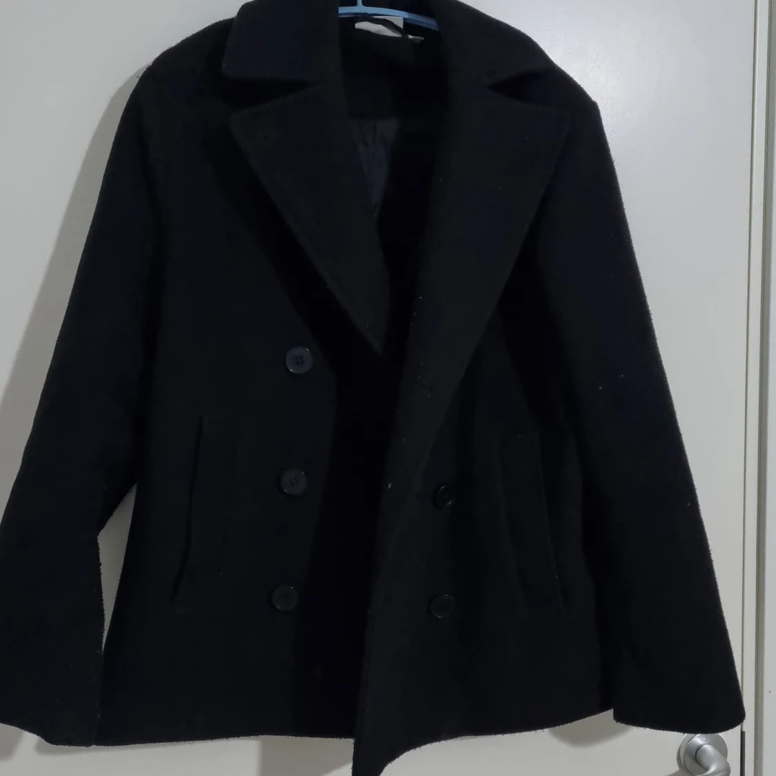 Svart kappa med knappar