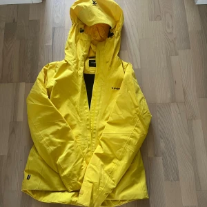 Gul skidjacka från Everest - Säljer en snygg gul skidjacka från Everest. Jackan har en praktisk huva och dragkedja framtill. 