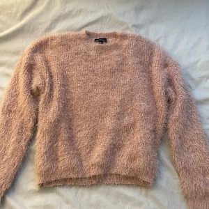 Rosa fluffig tröja från XOXO Friend - Säljer en supermjuk och fluffig rosa tröja från XOXO Friend. Perfekt för att hålla sig varm och mysig under kyliga dagar. Tröjan har en rund hals och långa ärmar, vilket gör den idealisk för lager-på-lager-stil. Passar perfekt för både vardag och avslappnade tillfällen. 💖