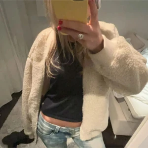 Beige teddyjacka - Mysig beige teddyjacka med dragkedja framtill. Perfekt för kyliga dagar och ger en avslappnad look. Jackan har långa ärmar och en bekväm passform. 