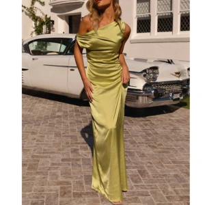  satin långklänning - Elegant grön långklänning i satin med en stilren oneshoulder-design. Perfekt för speciella tillfällen. Aldrig använt/prislappen är kvar då jag köpte fel storlek och kunde inte lämna tillbaka då den var från Australien💗