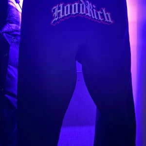 Svarta mjukisbyxor från Hoodrich - Snygga svarta mjukisbyxor från Hoodrich med ett coolt tryck på baksidan. Perfekta för en avslappnad stil. Passar ungdomar i åldern 13-15 år.