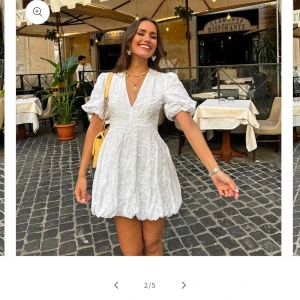 Vit klänning med blommigt mönster - Säljer en vacker vit klänning med blommigt mönster och puffiga kortärmar. Klänningen har en v-ringad design och är perfekt för sommarens festligheter. Den är tillverkad i ett lätt och luftigt material som ger en elegant look. Perfekt till studenten eller midsommar🌸pris kan såklart diskuteras, helt nytt skick säljer pga att den är för liten och inte går att skickas tillbaka 