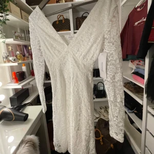 Student klänning - Elegant vit klänning i spets med v-ringad design och långa ärmar. Perfekt för studenten eller till sommaren💖