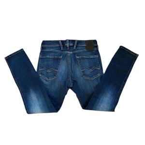 Blå Replay Jeans - Snygga blå jeans från Replay i modellen Anbass Hyperflex. De har en klassisk femficksdesign med en knapp och dragkedja framtill. Jeansen har en modern tvättad look och är perfekta för en avslappnad stil. De är i storleken W31 L30 men passar W28-31. Kom gärna med frågor eller prisförslag 😇👖