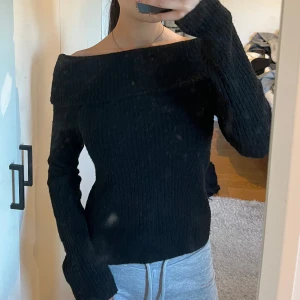 Svart ribbad offshoulder tröja från H&M - Säljer en stilren svart ribbad tröja från H&M med offshoulder-design. Perfekt för en trendig look med långa ärmar och en bekväm passform. Passar utmärkt till både jeans och kjol. 🖤