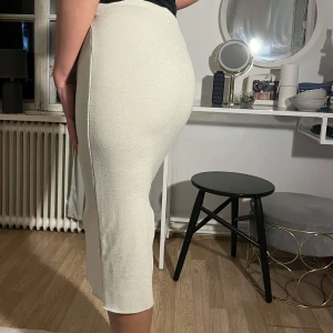 kjol med slit - En midi tight kjol med slit baktill i beige.