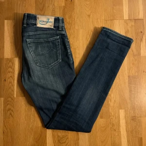 Blå jeans från Jacob Cohen - Snygga blå jeans från Jacob Cohen med en klassisk femficksdesign. De har en knappgylf med unika detaljer och en broderad logotyp. Tillverkade av utvalda japanska tyger med italienskt hantverk.