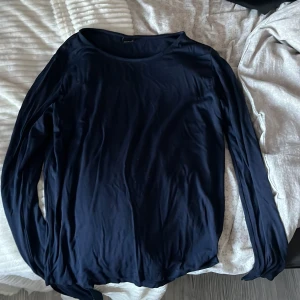 Mörkblå långärmad topp från Gina Tricot - Säljer en stilren mörkblå långärmad topp från Gina Tricot. Toppen har en rund halsringning och är tillverkad i ett mjukt material. Slim fit material och så himla skön, använt 1 gång då jag inte gillar så tajta tröjor längre. Ställ frågor om ni har några 🩷