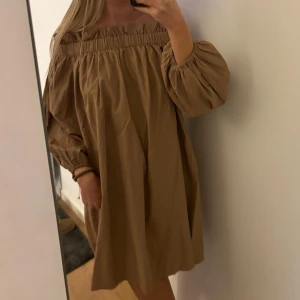 Klänning - Beige/brun off shoulder klänning, endast använt nån gång så i nytt skick! Storlek 38 men flexibelt resor så passar nog de flesta storlekar 